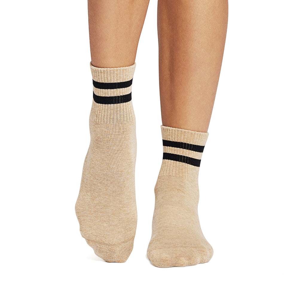 Beige socks with black stripes worn by a person on a white background