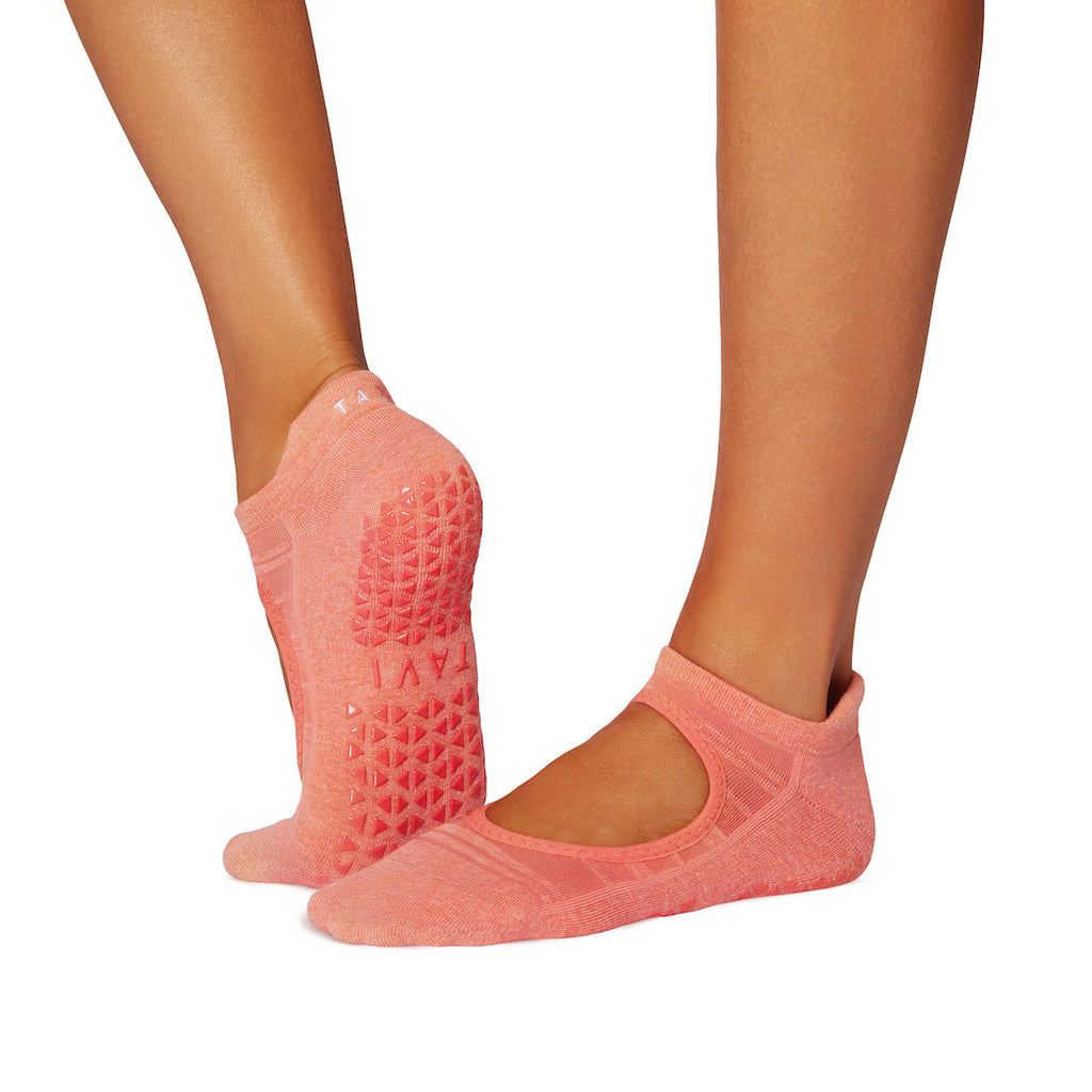 Pink grip socks worn by a person on a white background