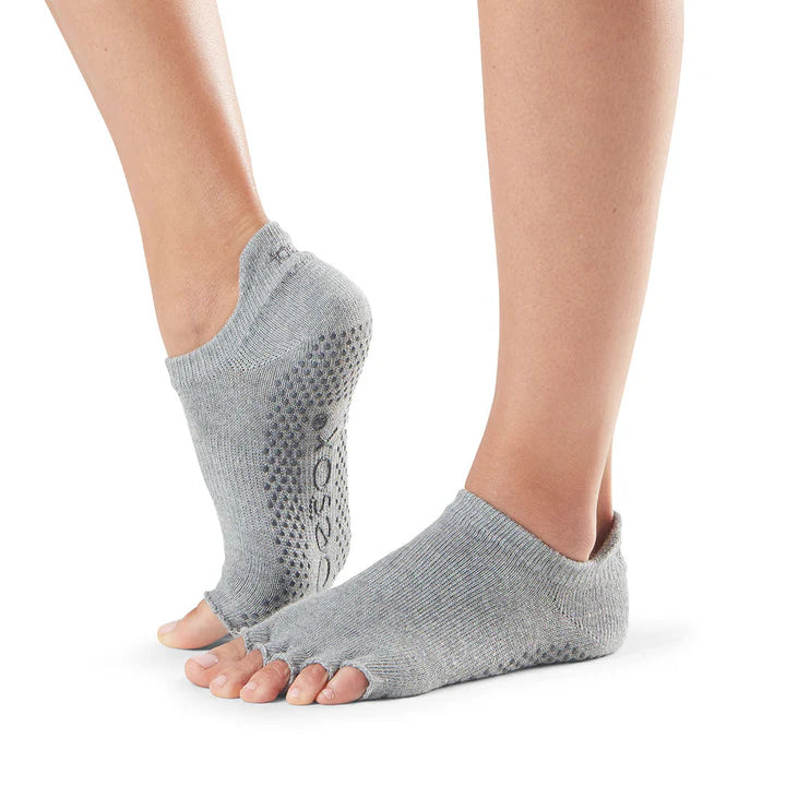 Gray toe-separated socks worn by a person on a white background