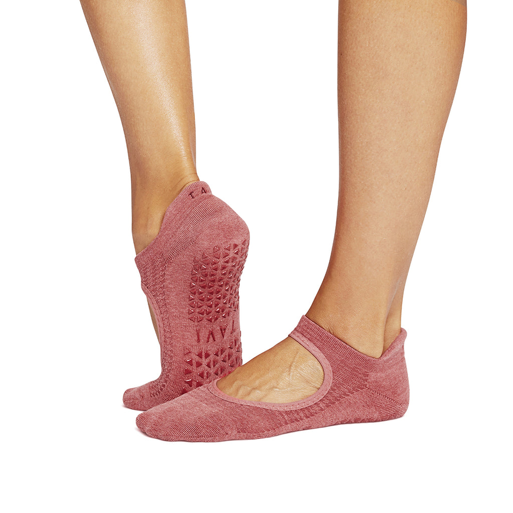 Pink socks with textured sole worn by a person on a white background