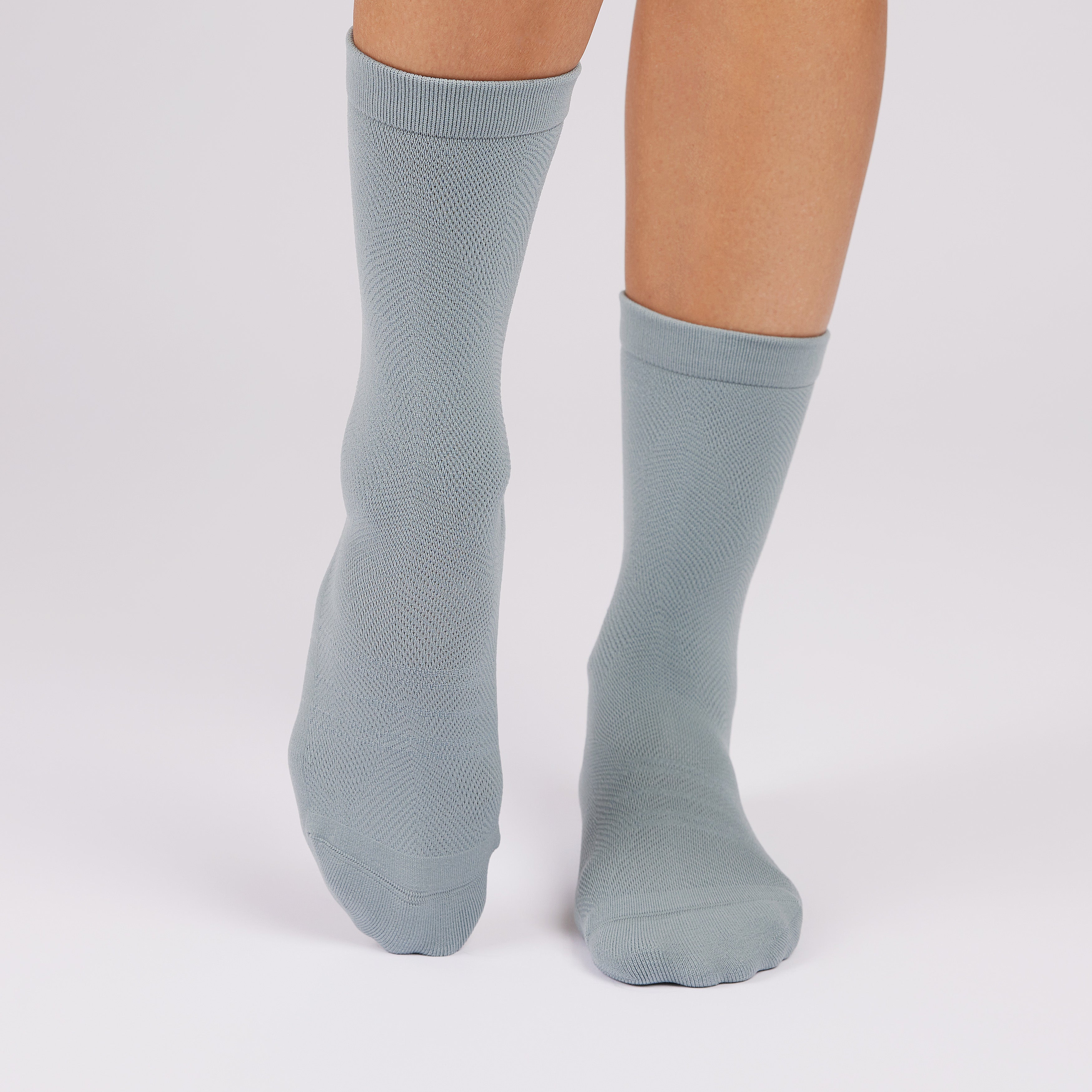 Light blue socks worn by a person on a white background