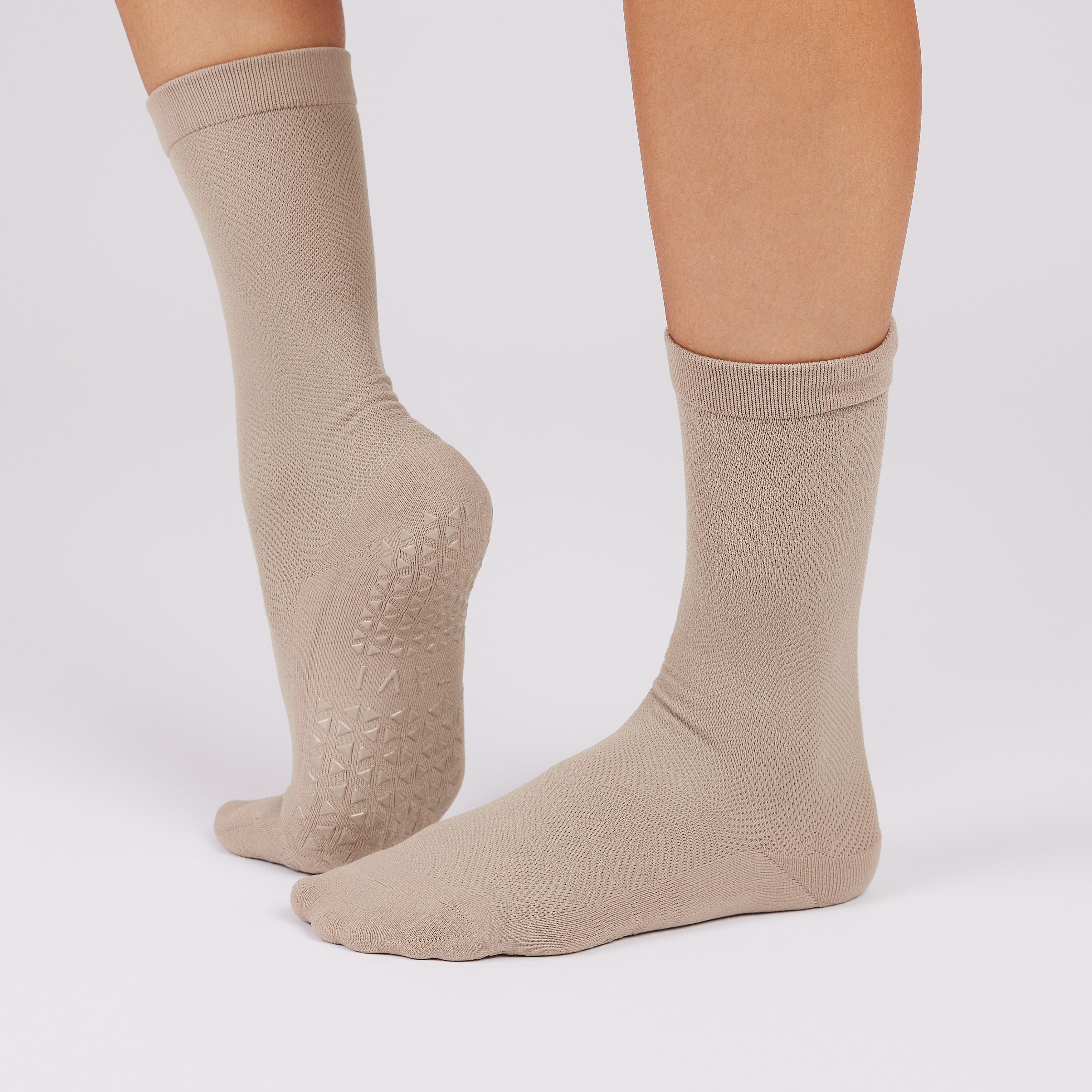 Beige socks with non slip sole on a white background