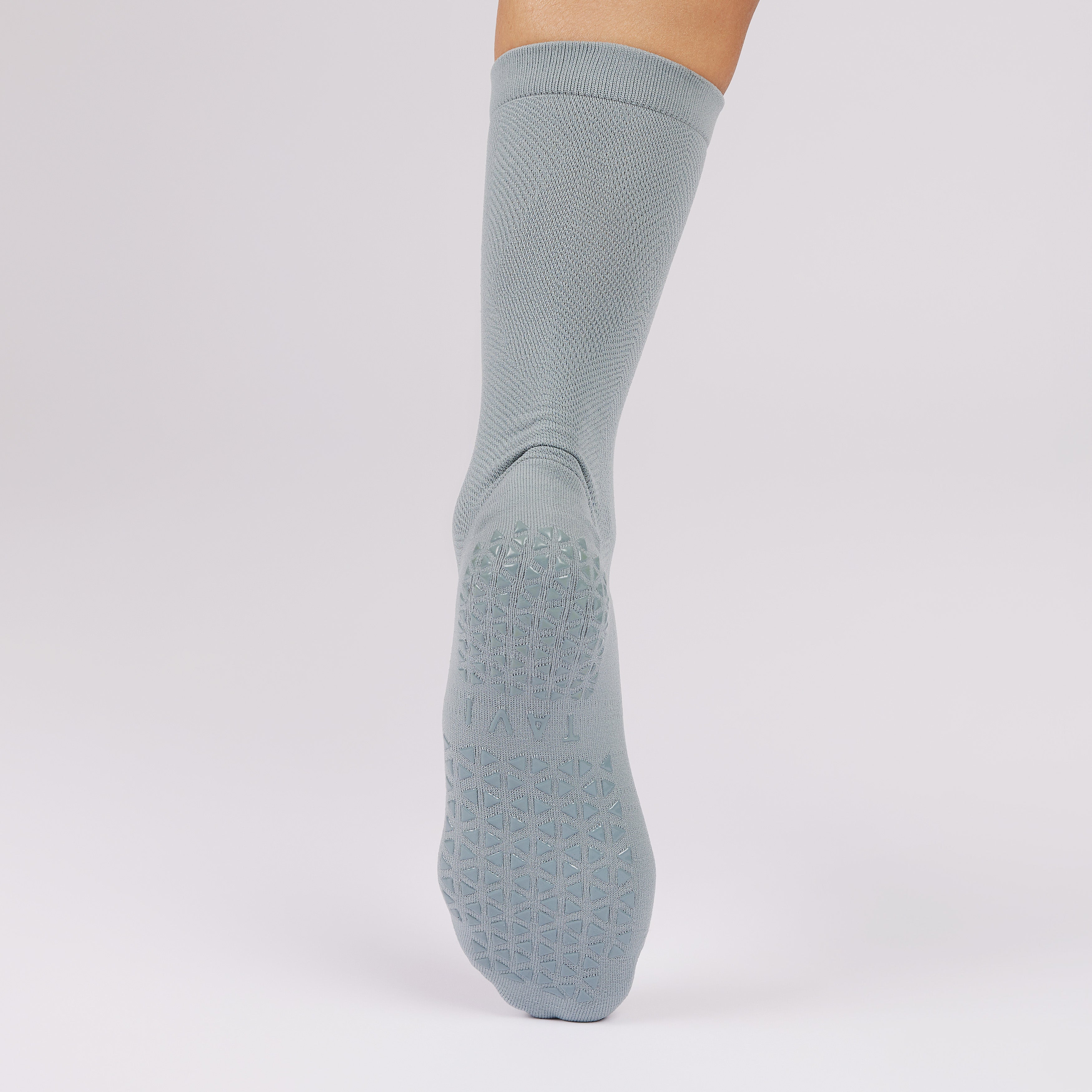 Gray sock with non slip sole on a light gray background