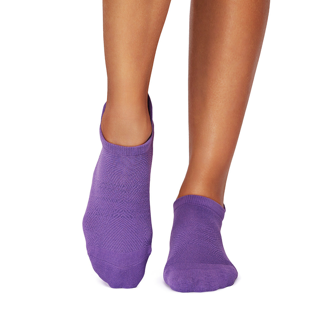 Purple grip socks worn by a person on a white background